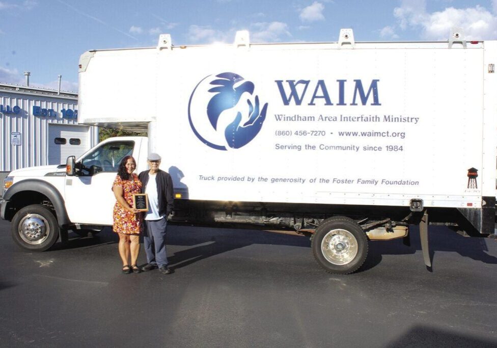 WAIM Executive Director Susan Hunter presents David Foster a plaque to thank him for donating a new truck.